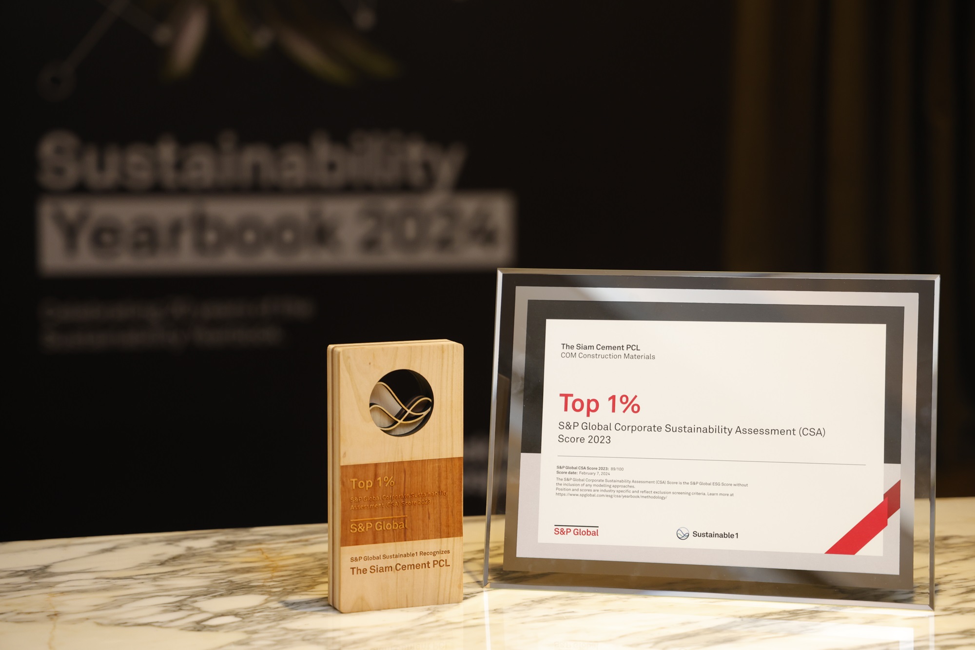 A wooden plaque and a paper on a marble tableDescription automatically generated
